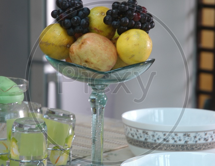 Photograph of Fresh fruits in a glass bowl on dining table