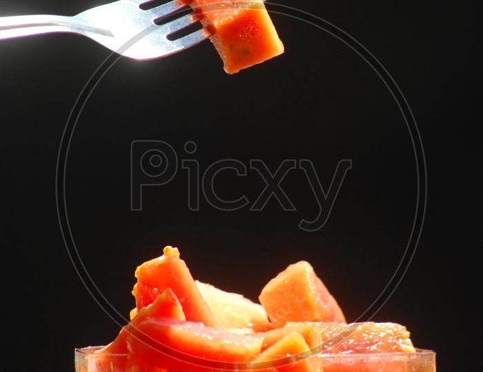 Papaya fruit pieces in a glass cup With fork