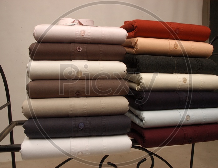 Stack of folded cotton men's shirts in multi color