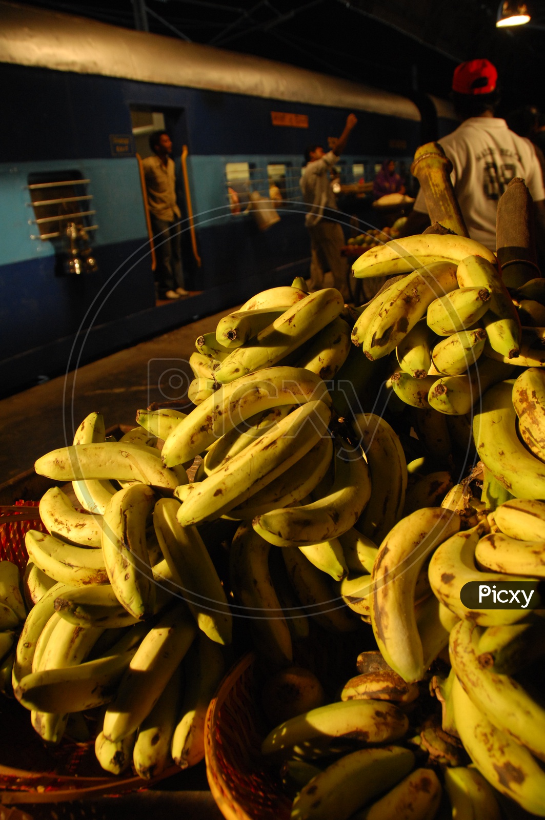 Photograph of banana's with train moving in the background