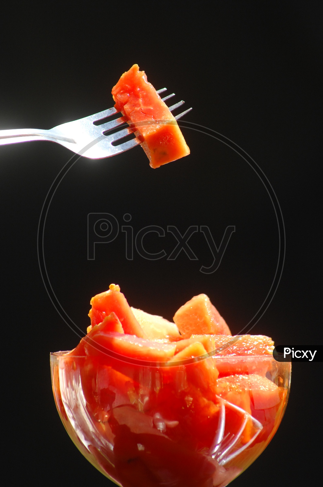 Papaya fruit pieces in a glass cup With fork