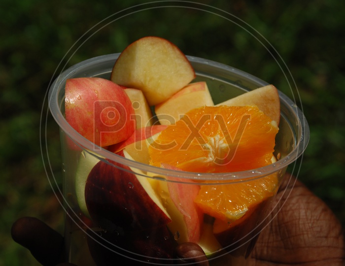 Apple and Orange fruit pieces in a plastic cup
