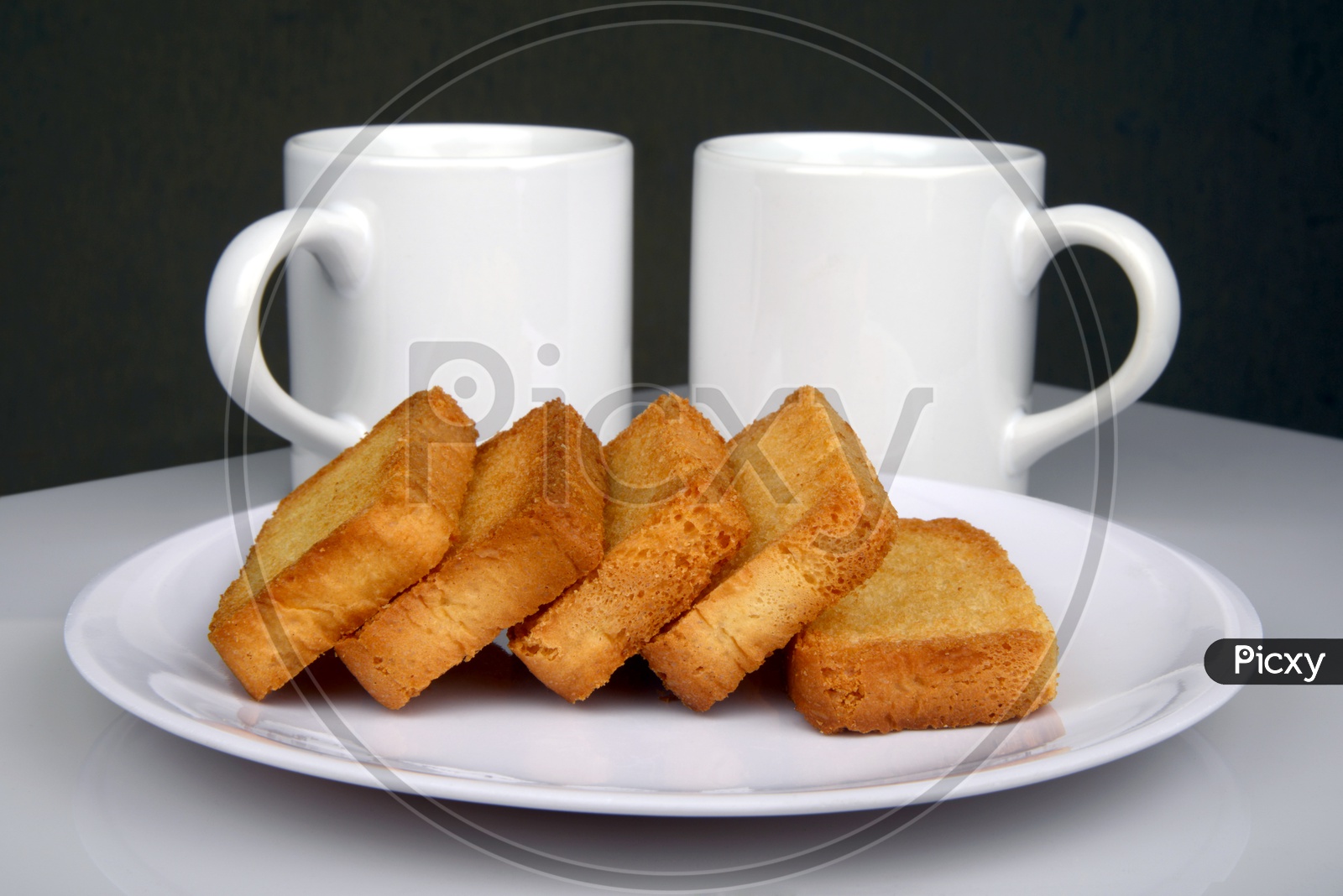 Sweet crispy rusk or toast and coffee mugs