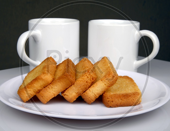 Sweet crispy rusk or toast and coffee mugs