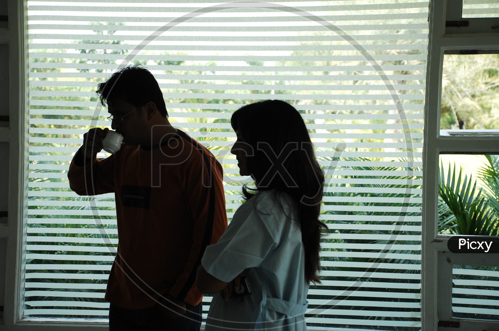 Actor Arjun with coffee cup in the hand talking to a Doctor - Movie Scene