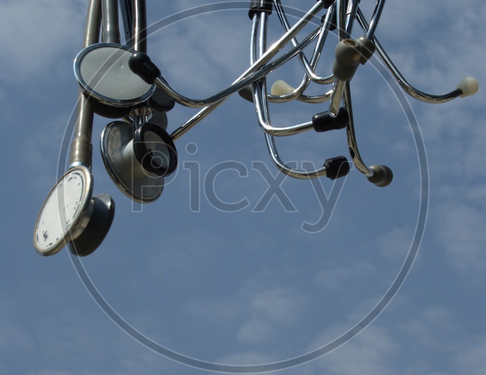 Photograph of stethoscopes hanging with sky in background