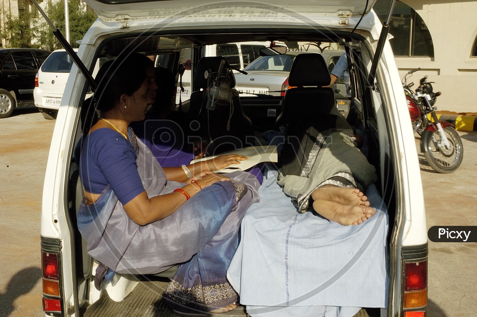 Women taking the patient to hospital in an ambulance