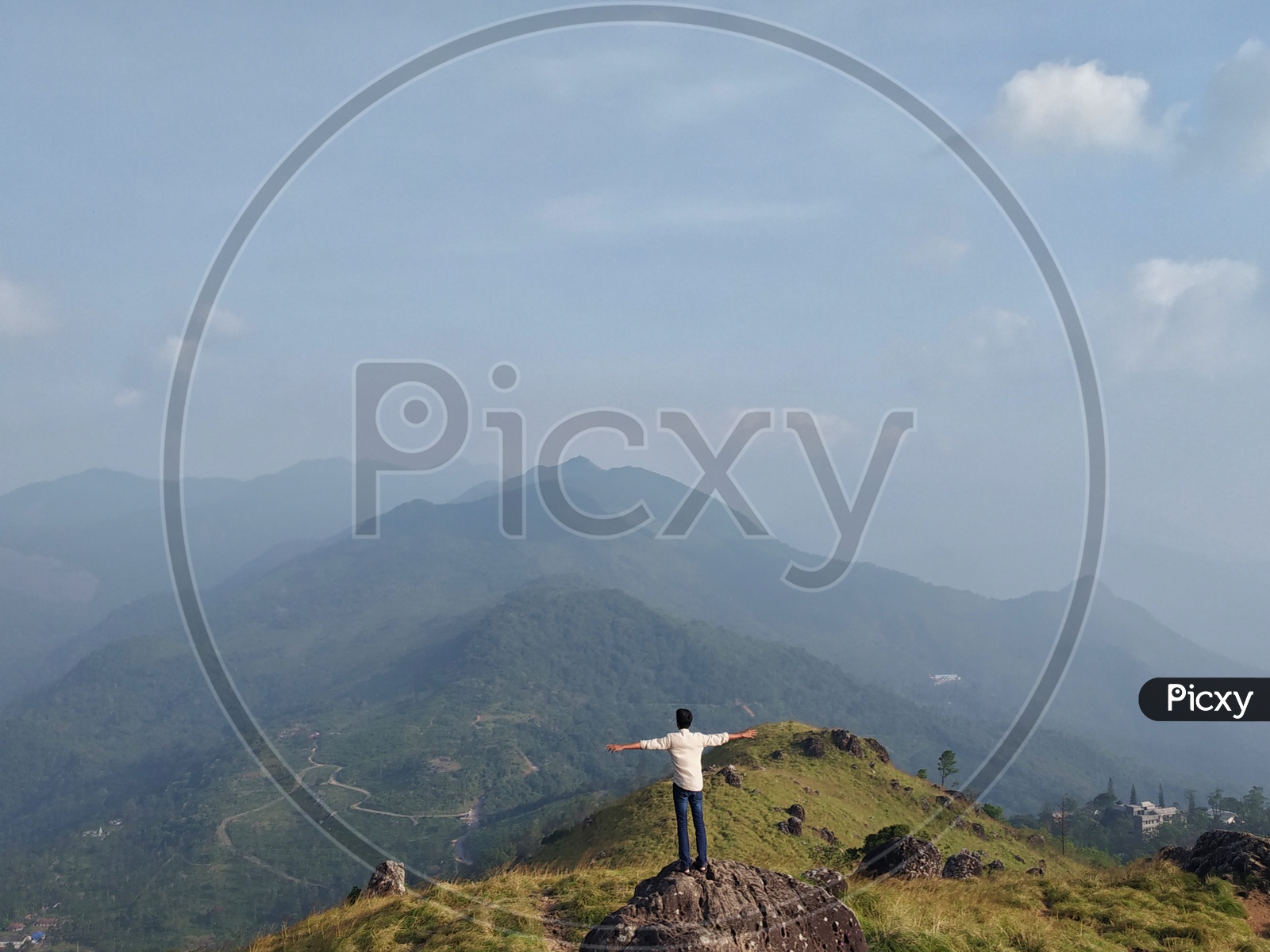 A person standing on a rock looking at the mountains