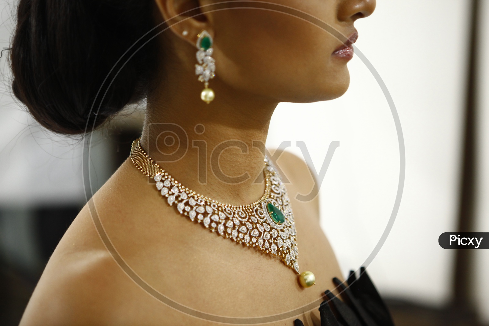 Female model wearing choker necklace with red Emerald and pearls