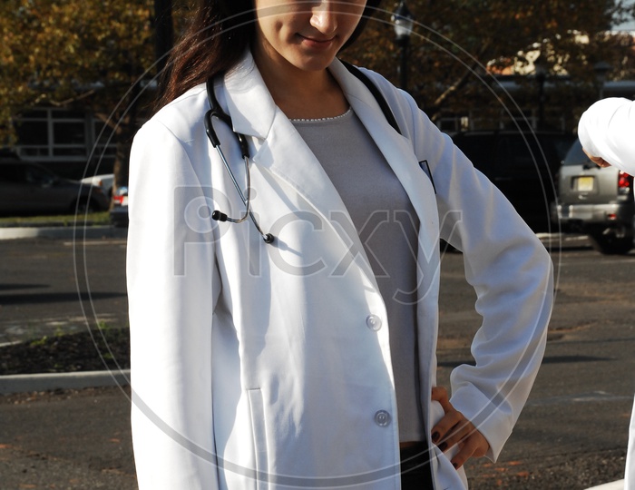 A female doctor with stethoscope wearing a long white coat