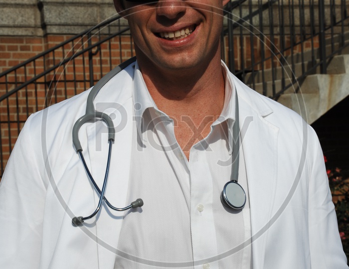 A male smiling doctors wearing white coat with stethoscope