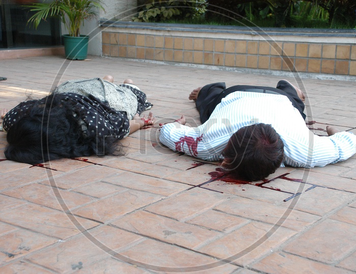 A man and a woman on the floor with blood stains - Movie scene