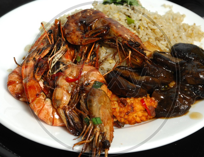 Cooked shrimp along with fried rice served in a white plate