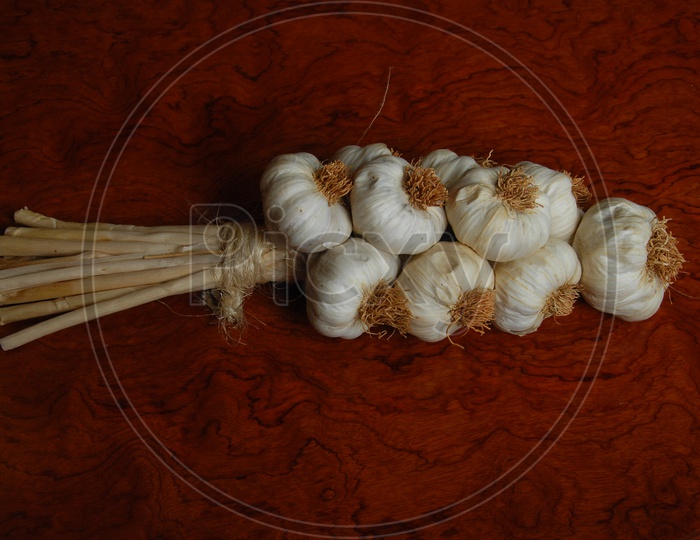 Braids of garlic on a red carpet background