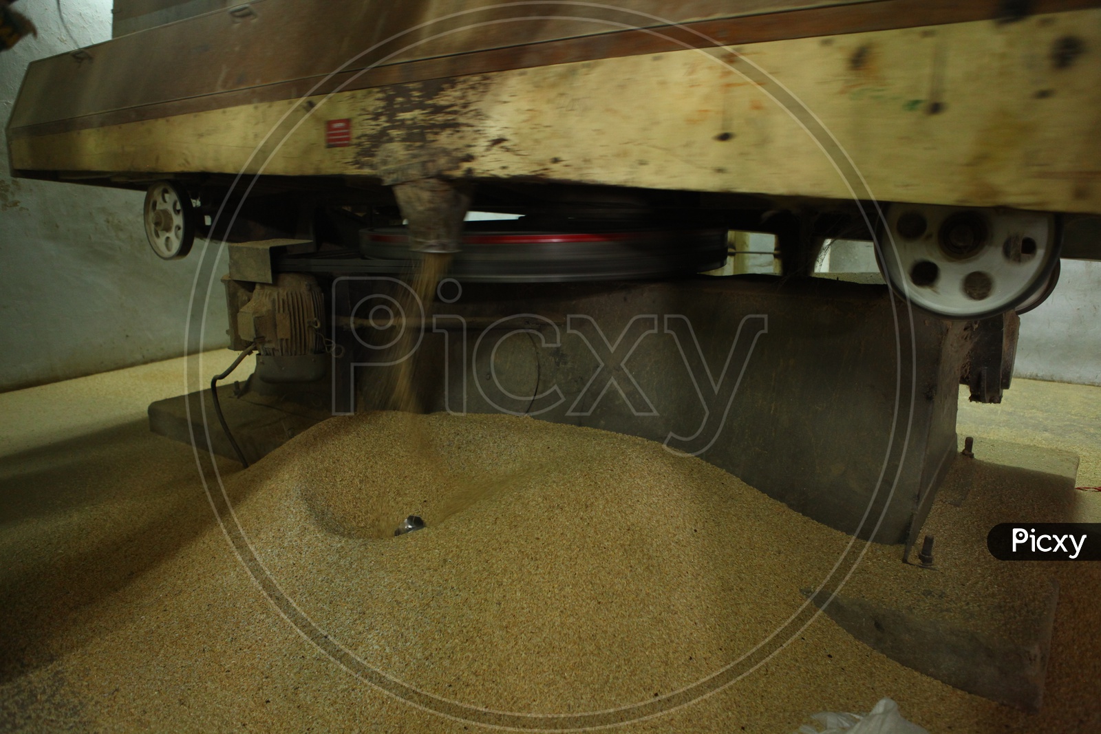 Broken rice coming out of nozzle from a machine in a rice mill