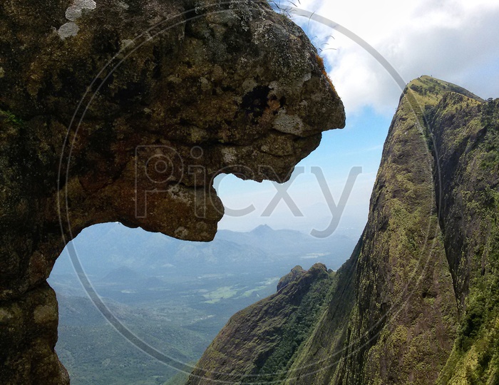 A rock with the shape of a panther overlooking the mountains