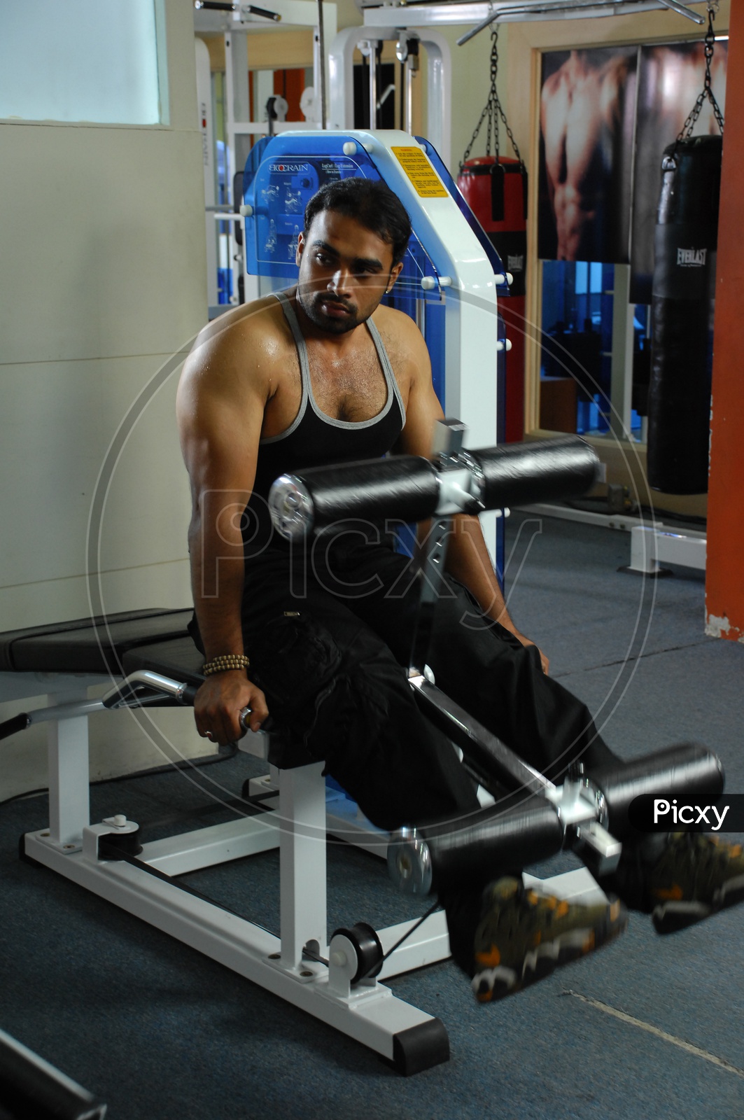 Man doing the Leg Extension Machine exercise in a Gym