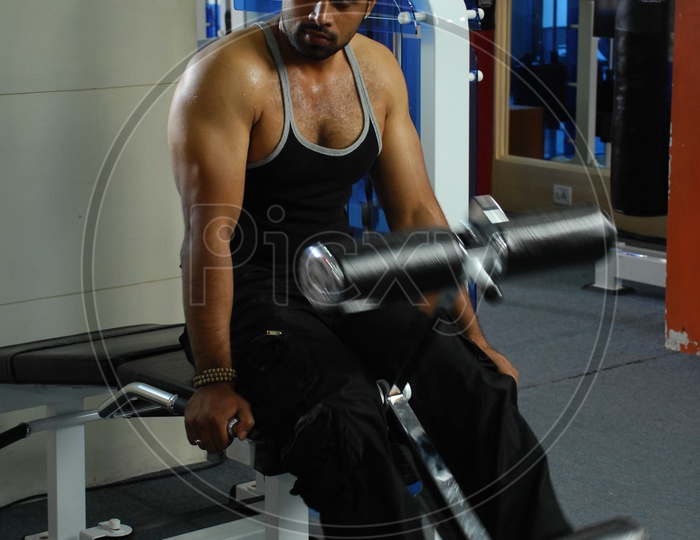 Man doing the leg extension Machine exercise in a Gym