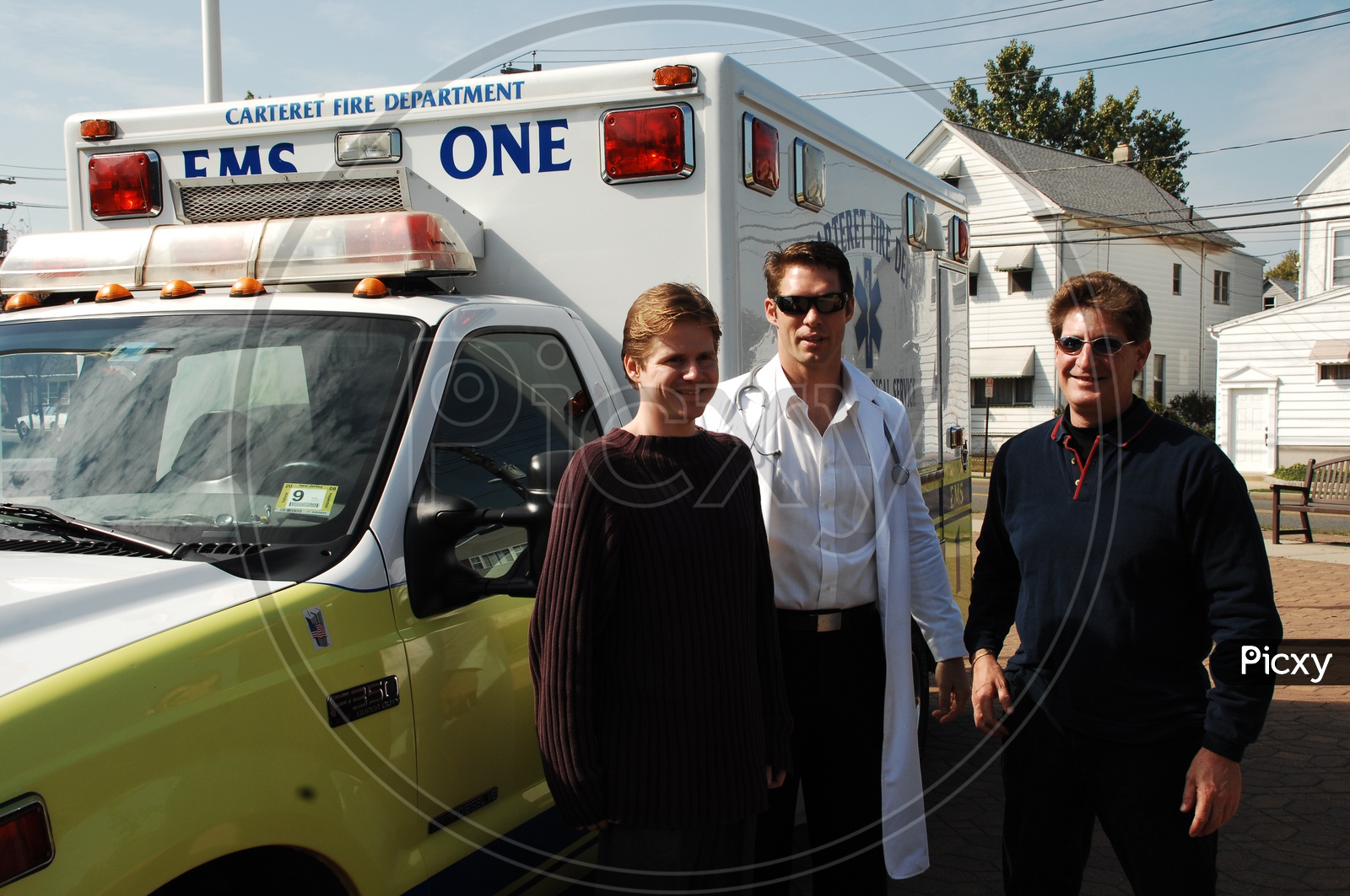 People and a doctor standing at the ambulance