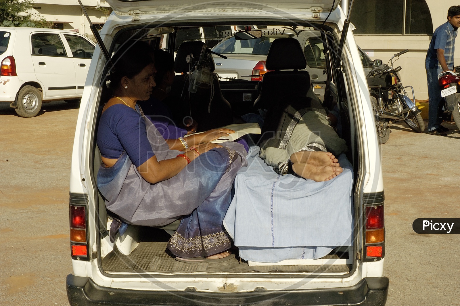 Women taking the patient to hospital in an ambulance