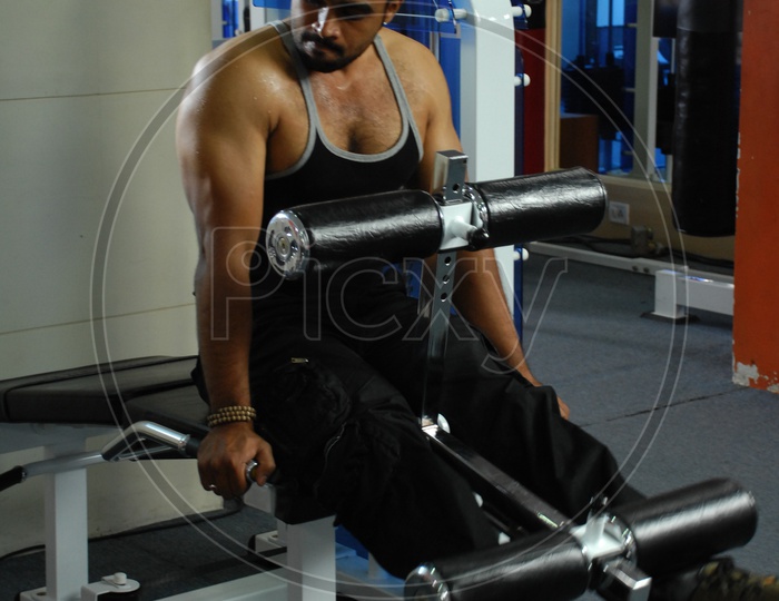 Man doing the Leg Extention Machine exercise in a Gym