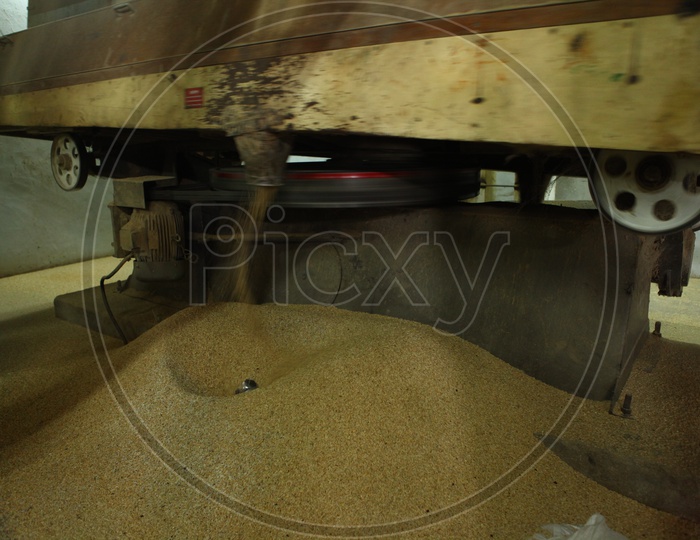 Broken rice coming out of nozzle from a machine in a rice mill