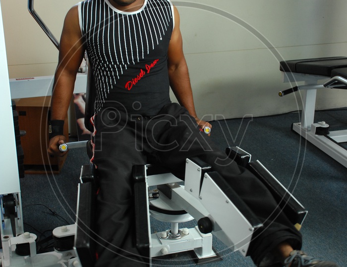 Man doing Leg Adduction / Abduction Machine exercise in a Gym