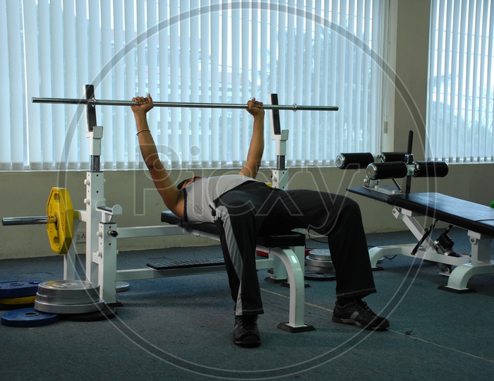 A man doing bench press in a gym