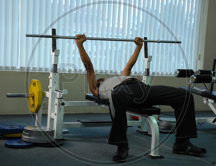 A man doing bench press in a gym