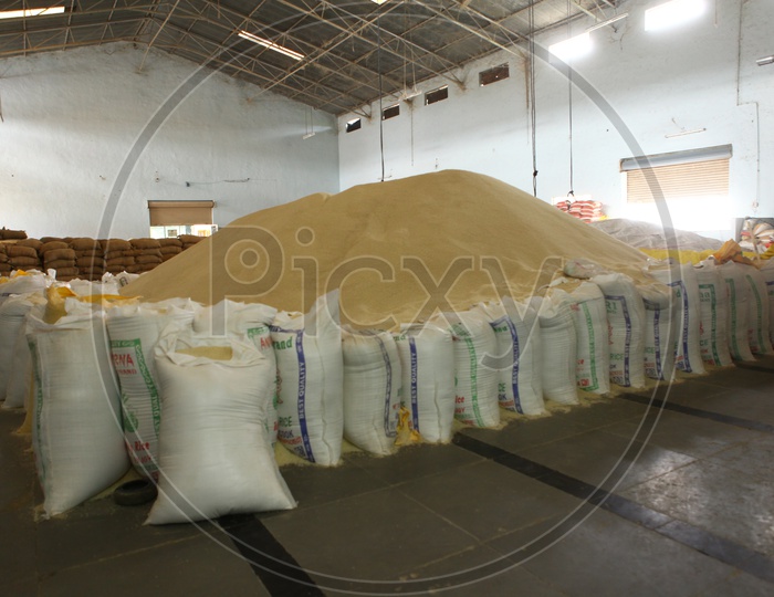 A big rice heap in Godown lined with rice bags in a rice mill