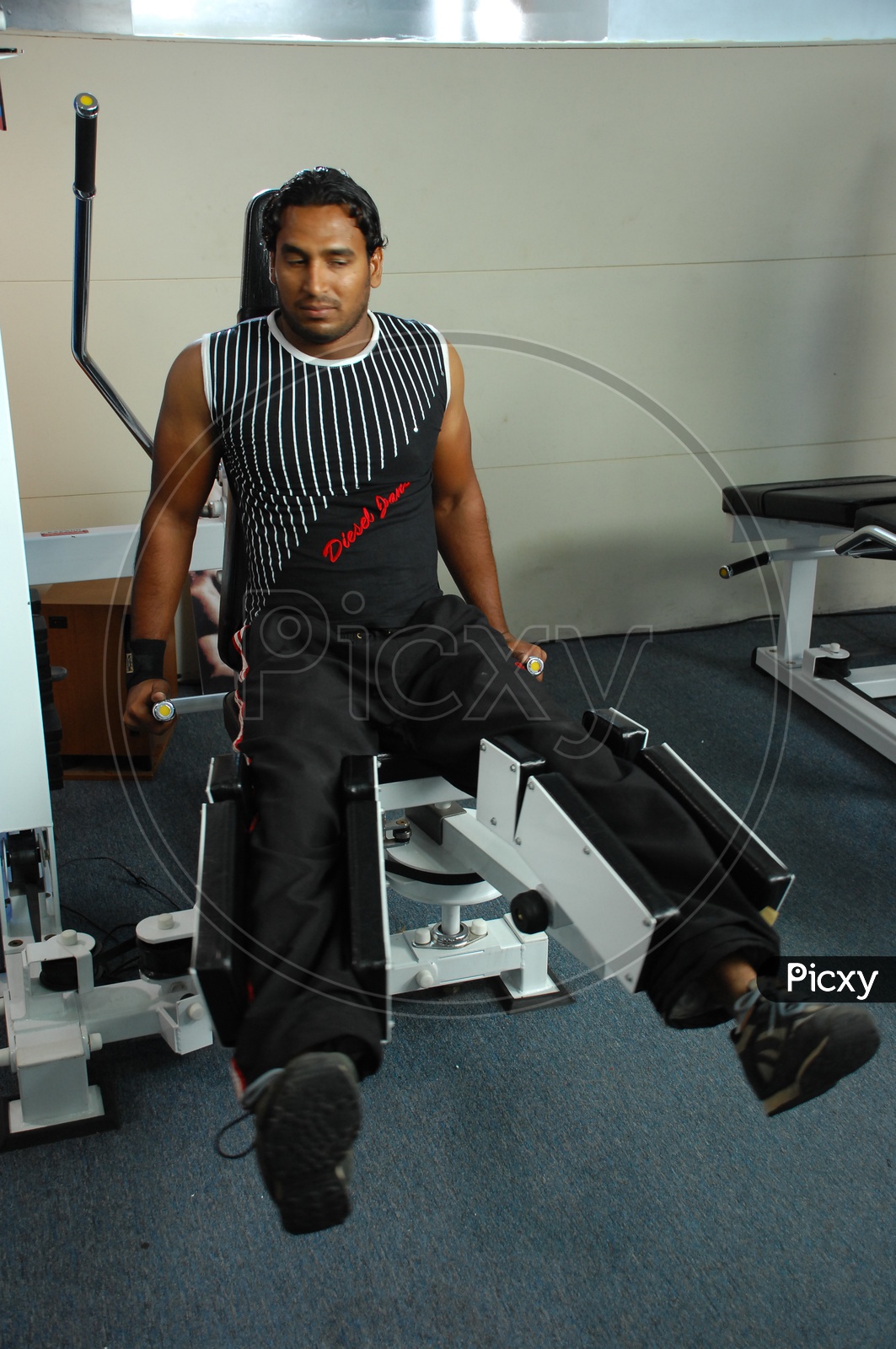 Man doing Leg Adduction / Abduction Machine exercise in a Gym