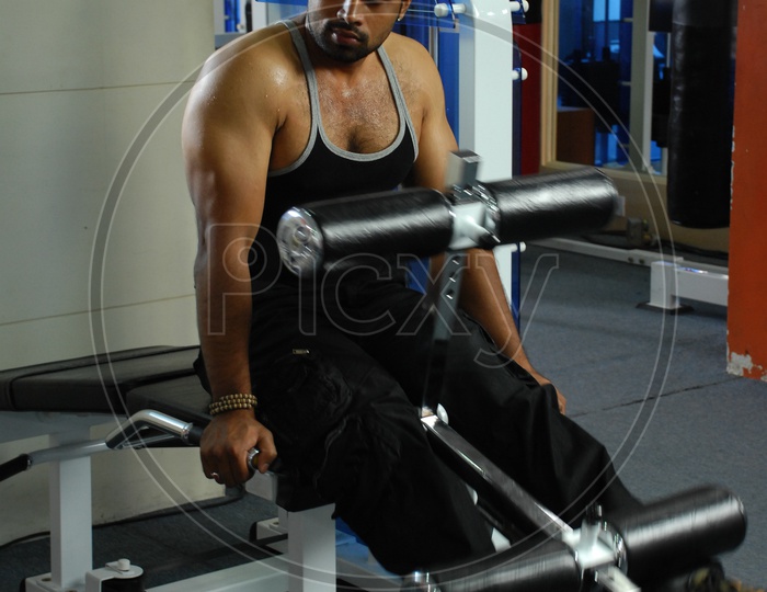 Man doing the Leg Extension Machine exercise in a Gym