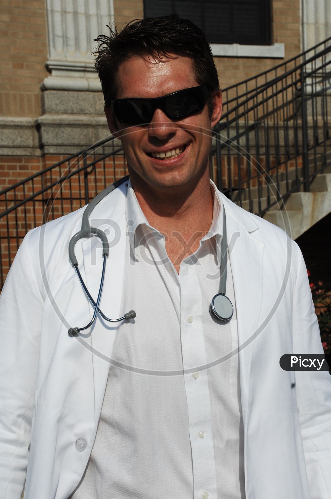 A male smiling doctors wearing white coat with stethoscope