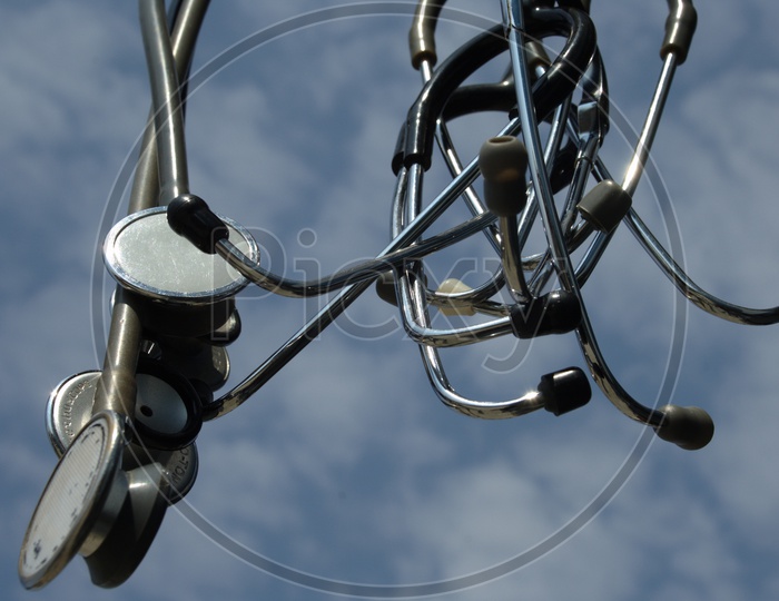 Photograph of stethoscopes hanging with sky in background