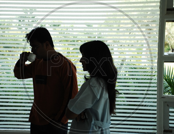 Actor Arjun with coffee cup in the hand talking to a Doctor - Movie Scene