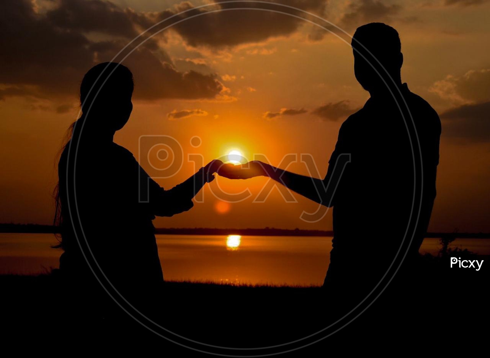 Silhouette Of a Couple Holding Hands Over a Sunset On a Beach