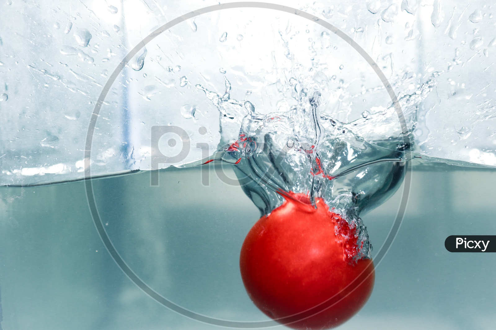 Splash made by dropping a red tomato in clear water