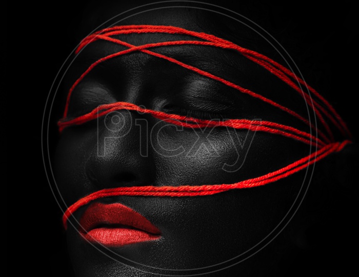 women face painted in balack and red and Black