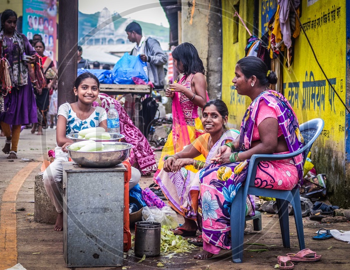 Indian Woman Vendors Of Cucumber on Street Side Chit chatting With Each Other With Smiling Face