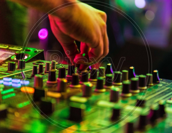 DJ Hands On the Audio Mixing Amplifier Buttons