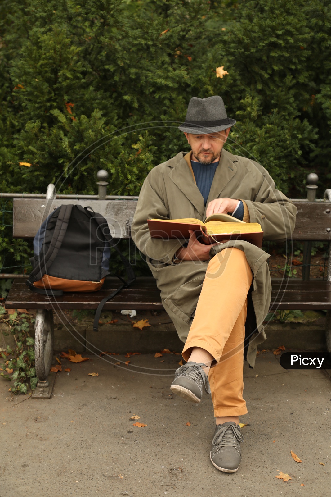A man sitting on a bench and reading a book