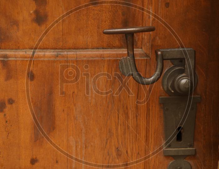 A metal handle on a wooden door