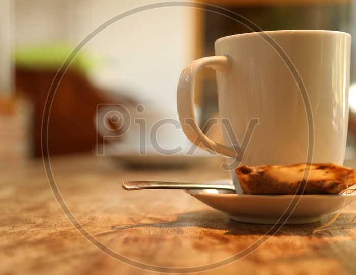 A white cup and saucer with a cookie