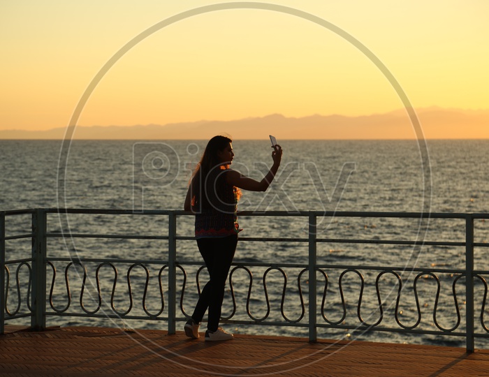 Silhouette of a woman taking selfie