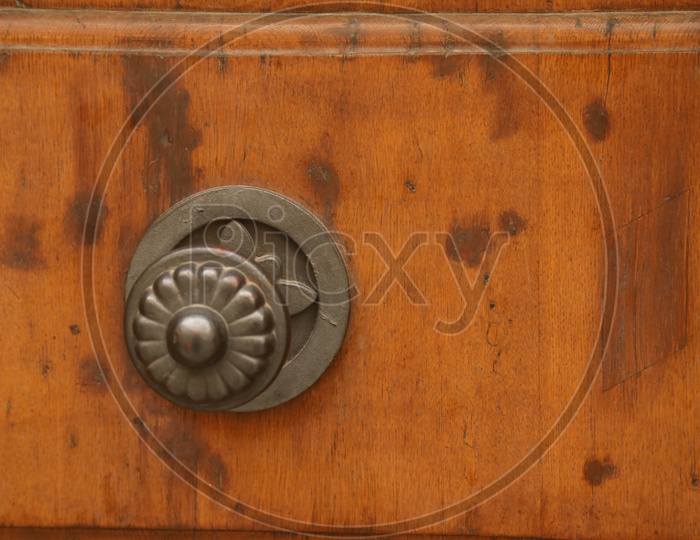 A metal handle on a wooden door