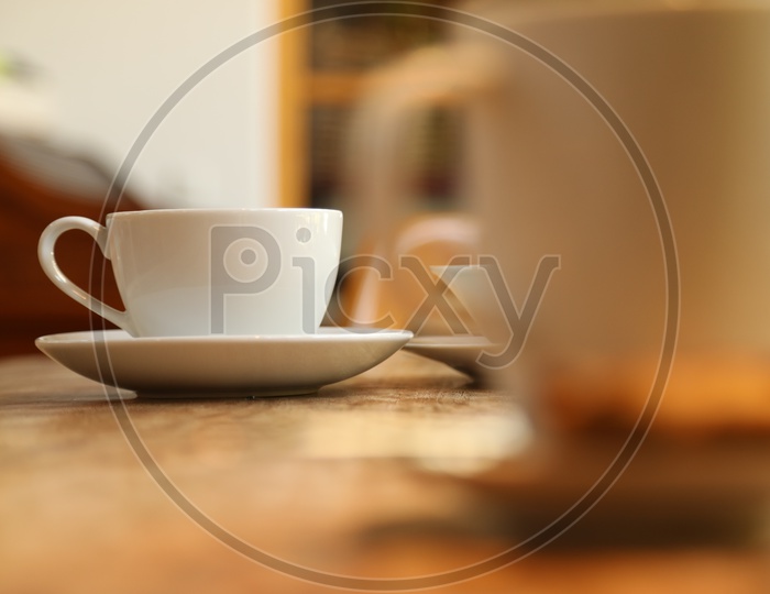 A white cup and a saucer on the table