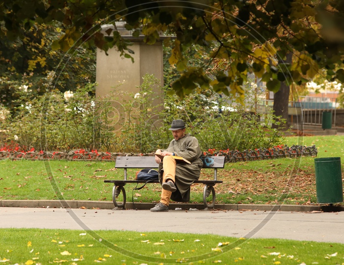 Man reading book in a park in Prague