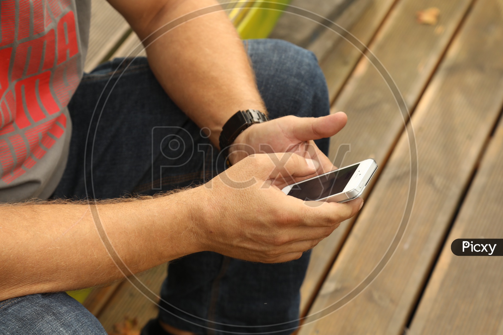 A mobile phone in the hands of a male person