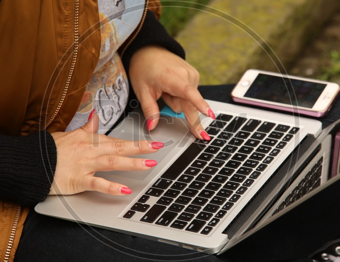 a woman Working Hands On Laptop(macbook and iPhone)