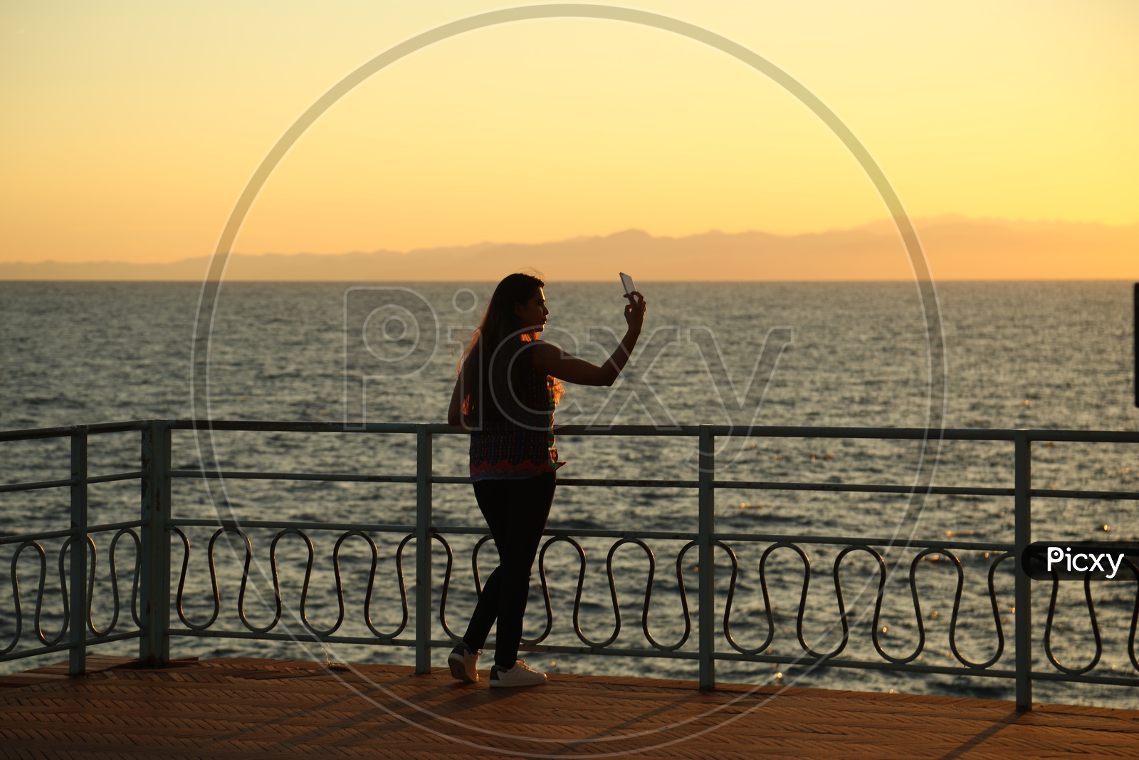 Silhouette of a woman taking selfie